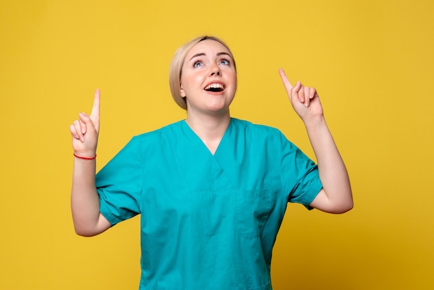 Vista frontal doctora en camisa médica, pandemia de enfermera covid-19 de emoción