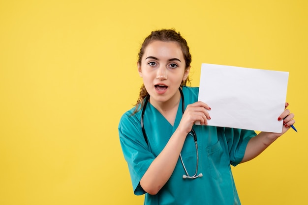 Vista frontal doctora en camisa médica con papeles y estetoscopio, emoción uniforme de covid-19 de salud pandémica de virus