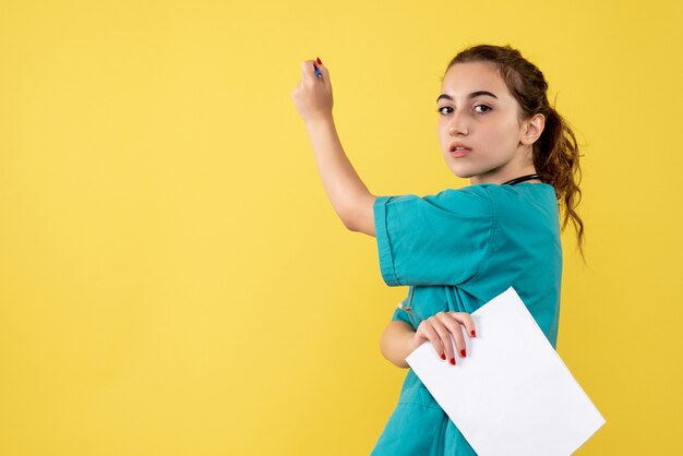 Vista frontal doctora en camisa médica con papeles y estetoscopio, virus de covid-19 de salud pandémica uniforme de emoción