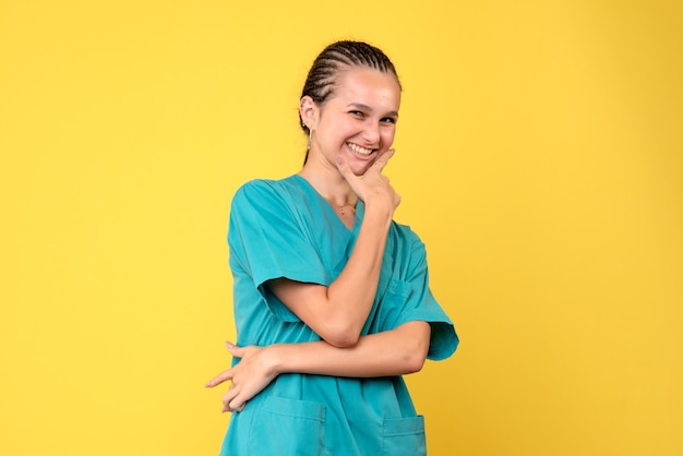 Vista frontal doctora en camisa médica sonriendo, enfermera de color de virus de hospital de salud covid-19