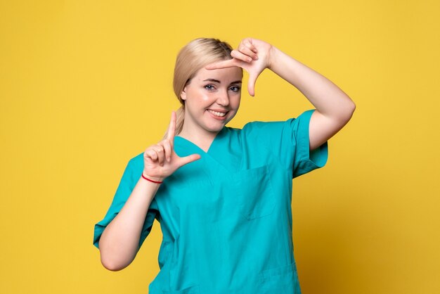 Vista frontal doctora en camisa médica sonriendo, enfermera médico covid emoción pandemia