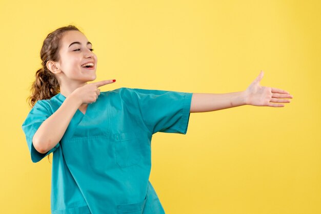 Vista frontal doctora en camisa médica sonriendo, uniforme emoción virus salud enfermera hospital