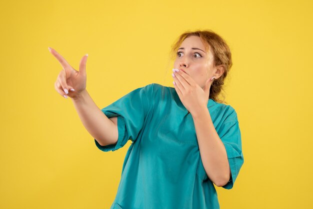 Vista frontal doctora en camisa médica sorprendida, color salud enfermera médico covid-19 emoción