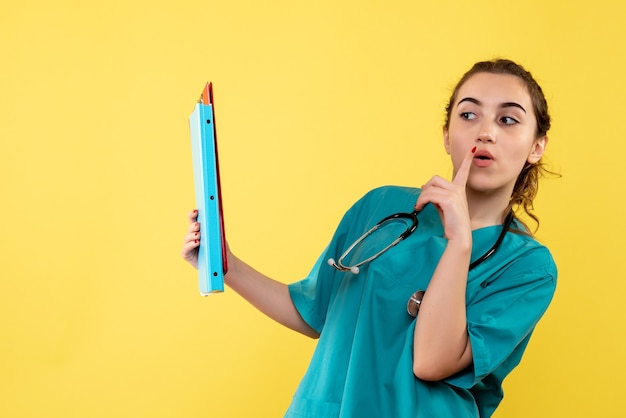 Vista frontal doctora en camisa médica sosteniendo diferentes notas, color virus salud emoción pandemia covid-19