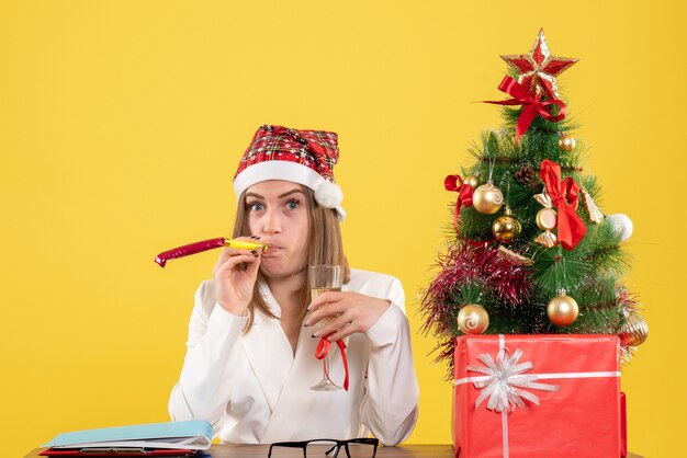 Vista frontal doctora celebrando la Navidad con champán