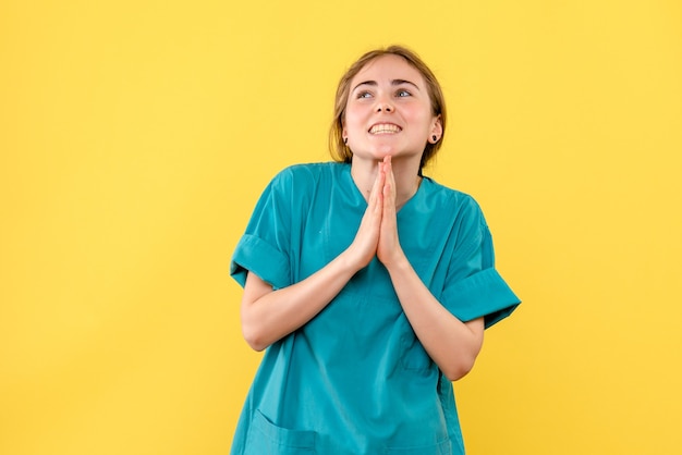 Vista frontal doctora emocionada sobre fondo amarillo médico de emoción de salud de hospital