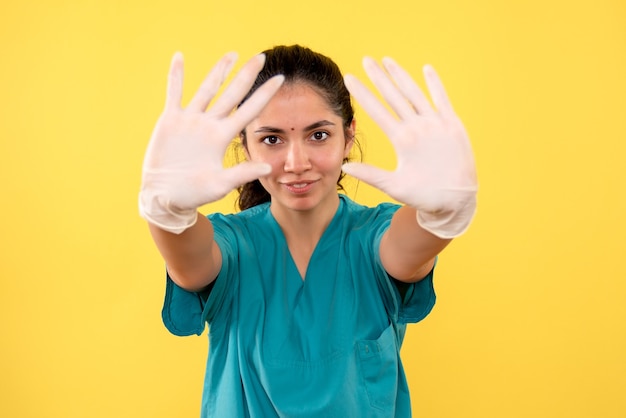 Vista frontal doctora con guantes de látex mostrando ambas manos