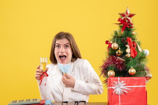 Vista frontal doctora en máscara estéril celebrando la Navidad