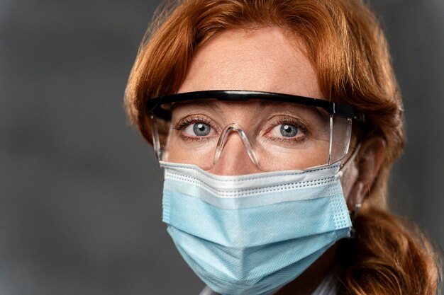 Vista frontal de la doctora con máscara médica y gafas de seguridad