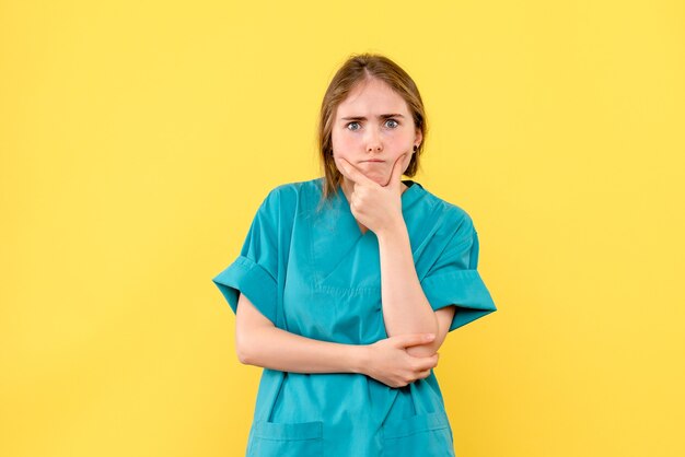 Vista frontal doctora pensando en un virus de salud de fondo amarillo médico emoción hospital