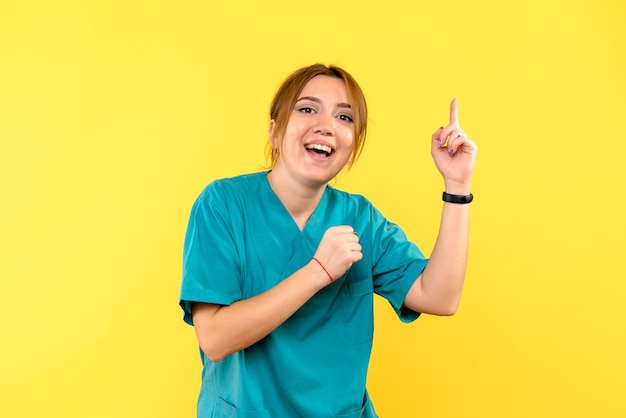 Vista frontal doctora sonriendo en espacio amarillo