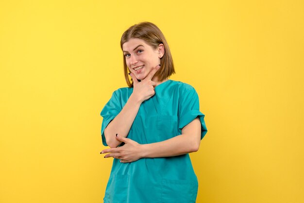 Vista frontal doctora sonriendo en espacio amarillo