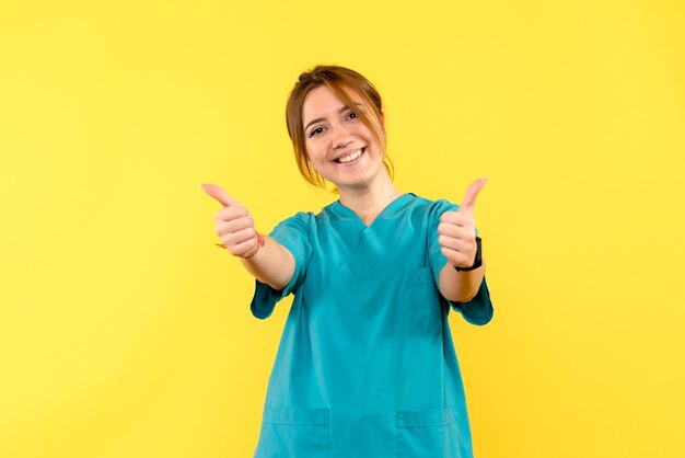 Vista frontal doctora sonriendo en espacio amarillo