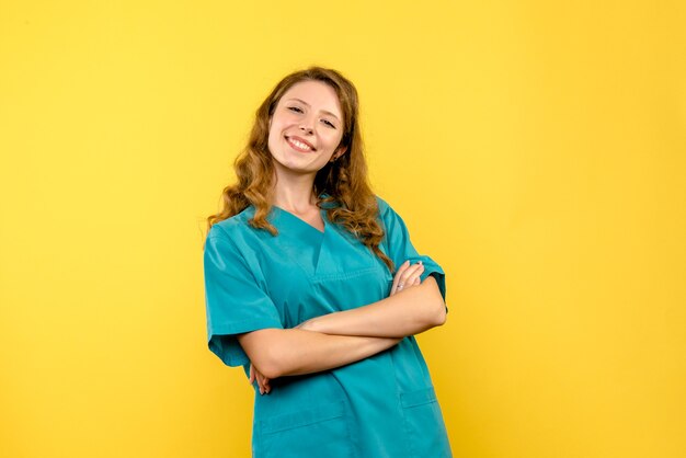 Vista frontal doctora sonriendo en espacio amarillo