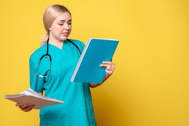 Vista frontal doctora sosteniendo análisis, médico de salud pandémica covid-19 hospital enfermera virus ambulancia