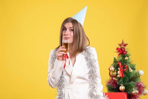 Vista frontal doctora sosteniendo una copa de champán y celebrando
