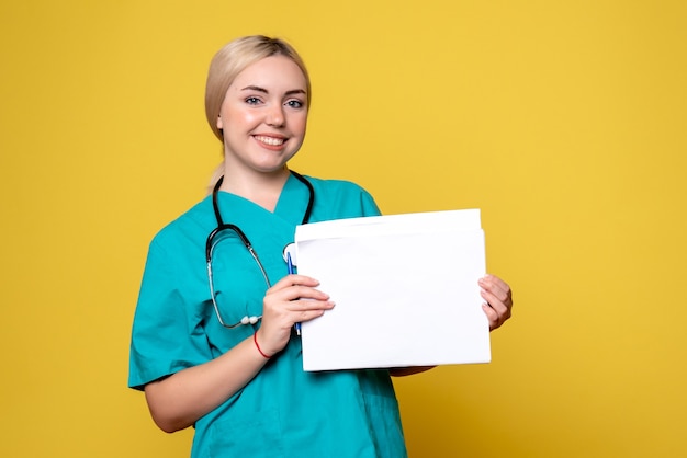 Vista frontal doctora sosteniendo diferentes papeles, virus de enfermera de hospital covid-19 de salud pandémica