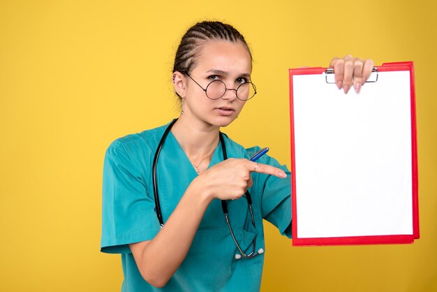 Vista frontal doctora sosteniendo portapapeles médico y bolígrafo, color enfermera hospital emociones covid-19 medic health