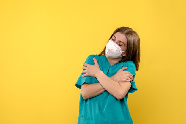 Vista frontal doctora temblando en espacio amarillo