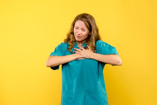 Foto gratuita vista frontal doctora teniendo dolor de corazón en el espacio amarillo