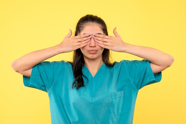 Vista frontal doctora en uniforme cubriendo sus ojos con las manos