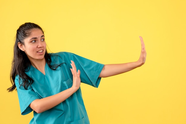 Vista frontal doctora en uniforme haciendo señal de stop