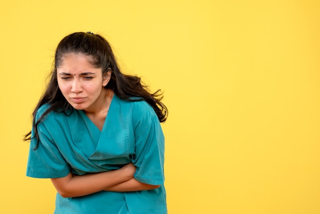 Vista frontal doctora en uniforme sosteniendo su estómago dolorido