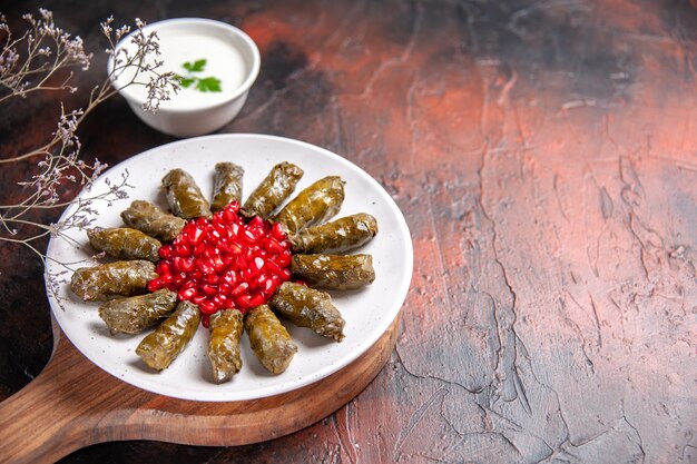 Vista frontal de la dolma de hoja verde con granadas en superficie oscura