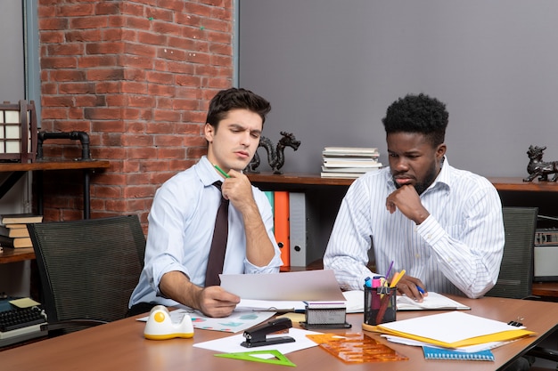 Vista frontal de dos empresarios serios negociando negocios