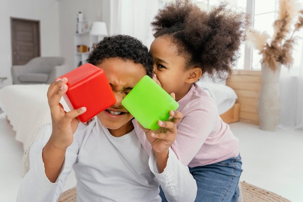 Foto gratuita vista frontal de dos hermanos jugando con cubos