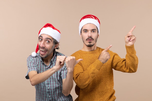 Vista frontal de dos hombres un feliz y un triste con gorro de Papá Noel, ambos mostrando algo sobre fondo aislado