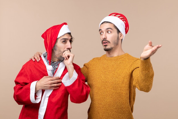 Vista frontal de dos hombres uno mostrando algo a otro sobre fondo beige aislado