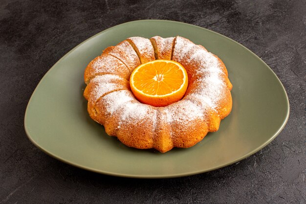 Una vista frontal dulce pastel redondo con varita de azúcar en polvo de naranja en el medio en rodajas dulce delicioso plato interior y en el fondo gris galleta galleta de azúcar