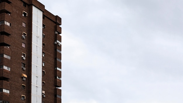 Vista frontal del edificio de apartamentos en la ciudad con espacio de copia