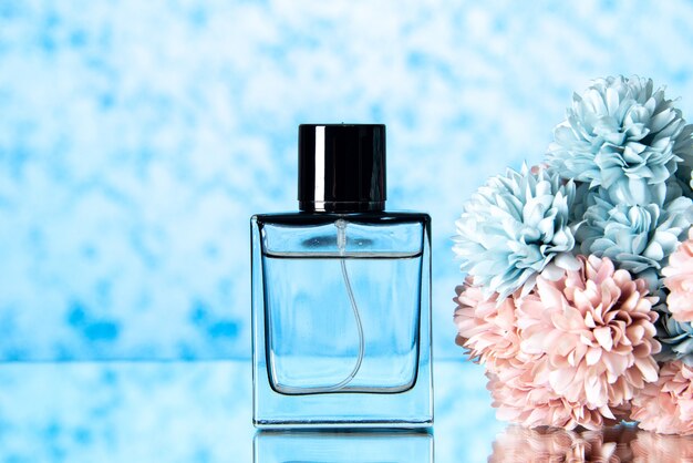 Vista frontal de un elegante perfume de flores de colores sobre fondo azul claro