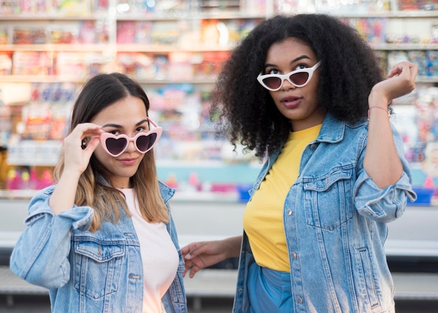 Vista frontal elegantes chicas jóvenes con gafas de sol