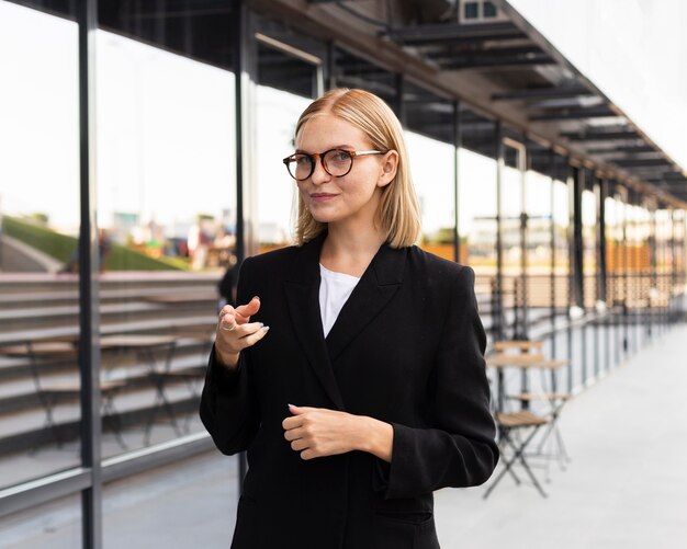 Vista frontal de la empresaria utilizando lenguaje de señas al aire libre en el trabajo