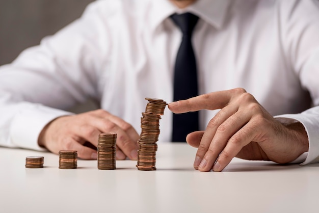 Vista frontal del empresario en traje y corbata con monedas