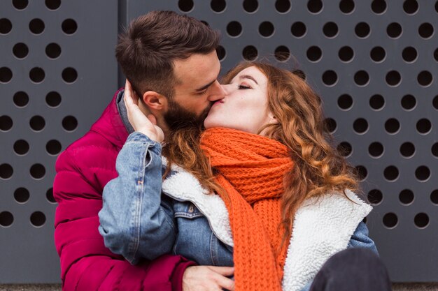 Foto gratuita vista frontal encantadora joven pareja besándose