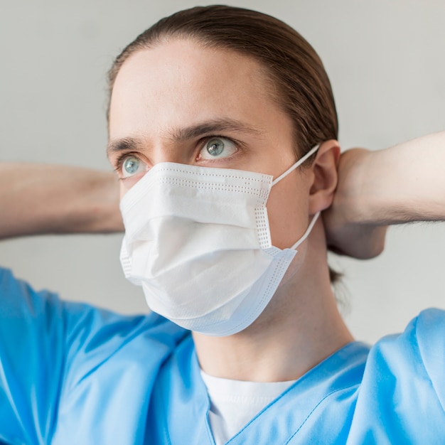 Vista frontal enfermero con máscara médica