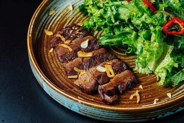 Vista frontal ensalada de carne con lechuga y pimiento rojo en un plato