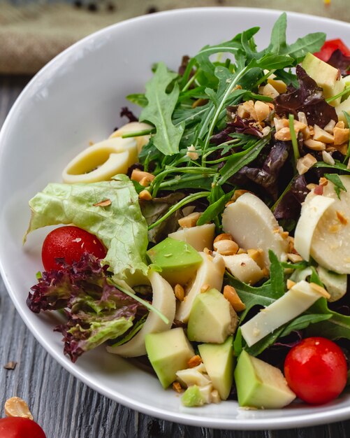 Vista frontal ensalada fresca con rúcula aguacate y tomate