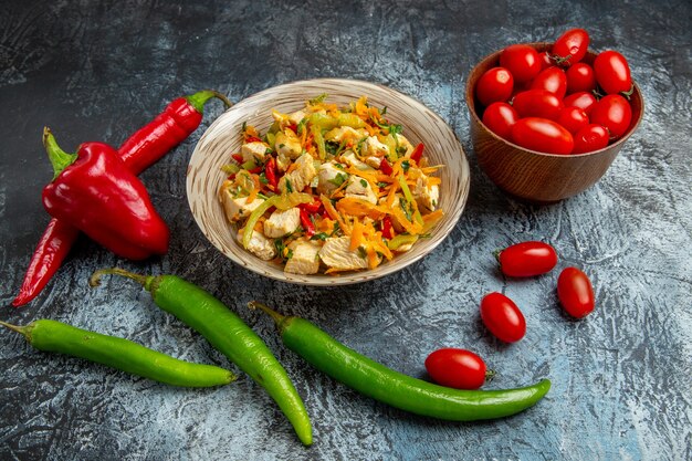 Vista frontal de ensalada de pollo con verduras frescas en superficie ligera