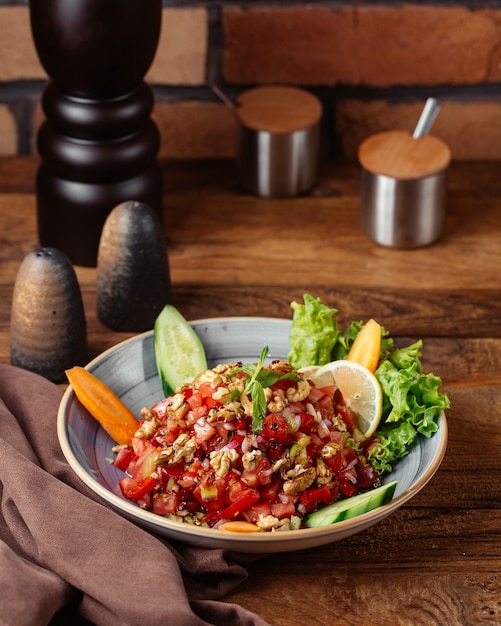 Vista frontal de una ensalada de verduras con limón dentro de la placa en la mesa de madera marrón comida comida vegetal