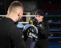 Foto gratuita vista frontal del entrenamiento de boxeadora con guantes protectores