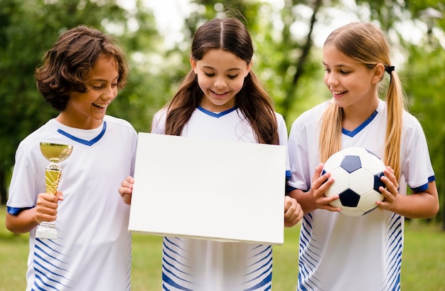 Vista frontal del equipo de fútbol ganador con una tarjeta vacía