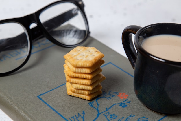 Una vista frontal estrecha taza de leche con gafas de sol y leche en la superficie de la luz