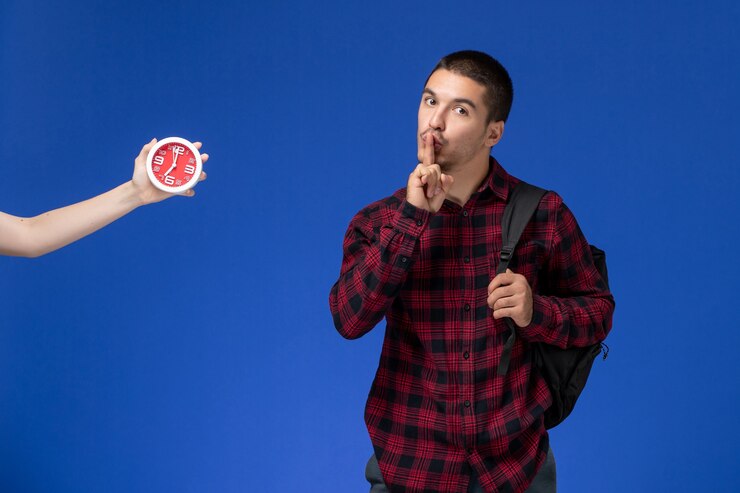 Foto gratuito vista frontal del estudiante en camisa a cuadros roja con mochila en la pared azul