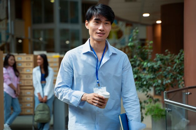 Vista frontal estudiante sonriente con taza de café