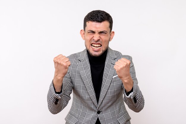 Vista frontal eufórico hombre guapo en traje mostrando gesto ganador de pie sobre fondo blanco.